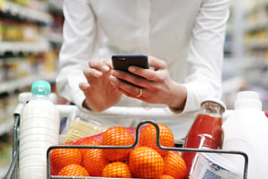 Woman looking at phone in Supermarket